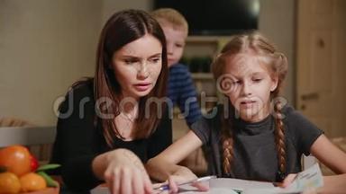 母女俩在做学校<strong>作业</strong>，一个小男孩在看。 哥哥<strong>帮</strong>忙做<strong>作业</strong>。